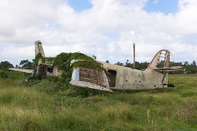 Abandoned aeroplane on field against sky