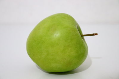 Close-up of apple on table against white background