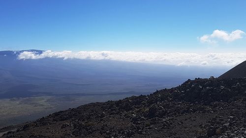 Scenic view of sea and mountains against blue sky