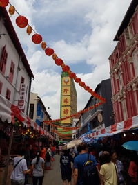 Low angle view of lanterns hanging against sky in city