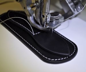 Close-up of machine sewing shoes