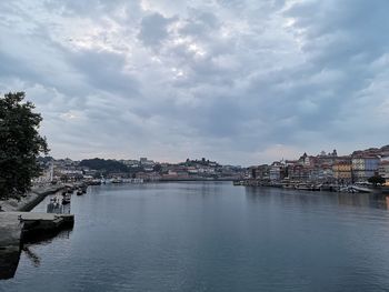 River amidst buildings in city against sky