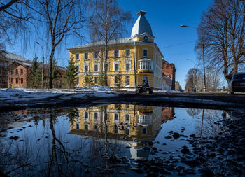 Reflection of building in lake against sky