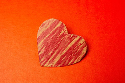 Close-up of heart shape against orange background