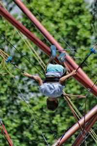 Low angle view of men hanging on rope