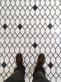 Low section of man standing on tiled floor