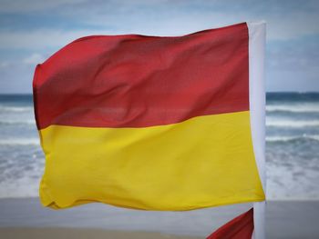 Close-up of yellow flag against sky