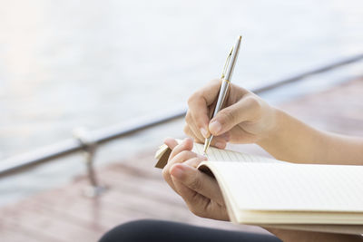 Close-up of person writing in book