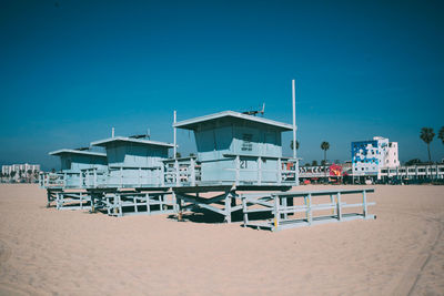 Lifeguard hut on beach against clear blue sky