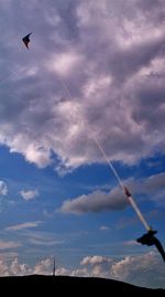 Low angle view of airplane flying against cloudy sky