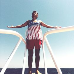 Full length of young woman standing by railing