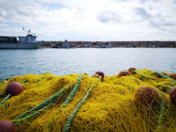 Close-up of fishing net in sea against sky