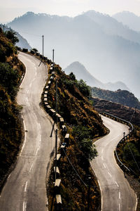 Empty road by mountain against sky