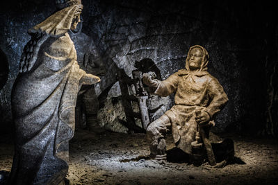 Statue against wall at night