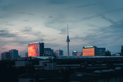 Modern buildings in city against sky at dusk