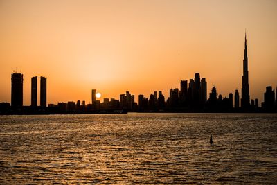 Silhouette of buildings against sky during sunset