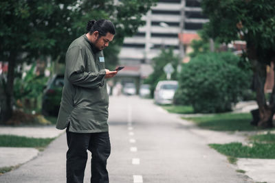 Full length of man standing on road in city