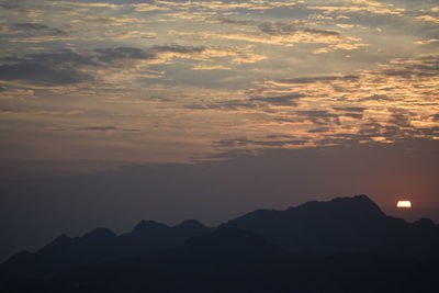 Scenic view of silhouette mountains against sky at sunset