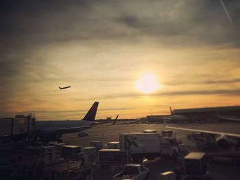 Airplane flying in sky at sunset