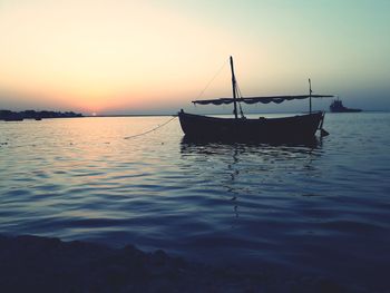 Sailboats in sea against sky during sunset