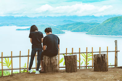 Rear view of couple standing on railing