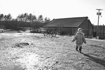 Man walking on snow field against sky