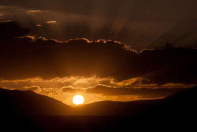 Scenic view of silhouette mountains against sky during sunset