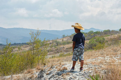 Full length of woman standing on land against sky
