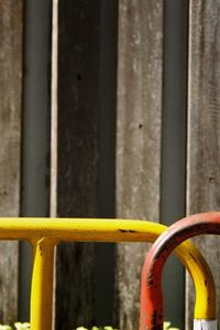 Close-up of yellow railing against window