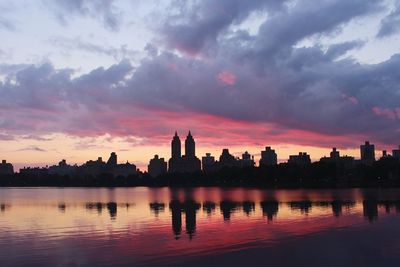 Central park reservoir against silhouette skyline during sunset