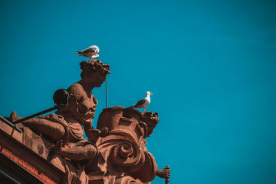 Low angle view of statue against clear blue sky