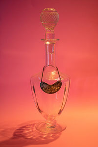 Close-up of illuminated lamp on table against red background