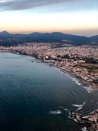 High angle view of townscape by sea against sky