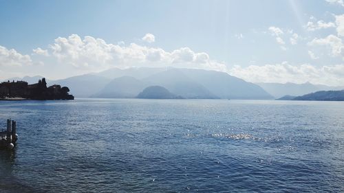 Scenic view of sea by mountains against sky