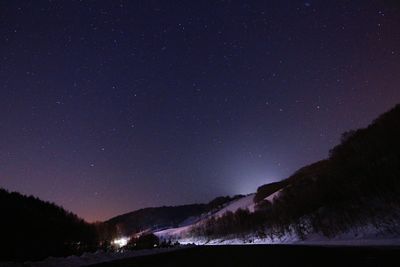 Scenic view of landscape against star field at night