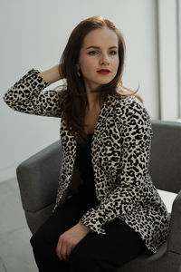 Portrait of young woman sitting on sofa at home