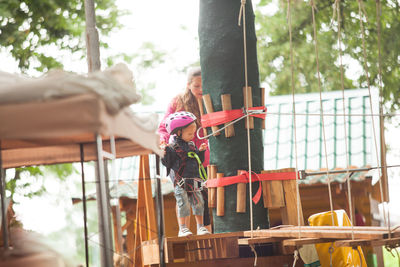 Woman holding umbrella standing on wood