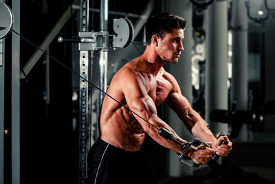 Shirtless man exercising in gym