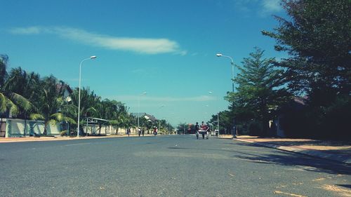 People on road in city against sky