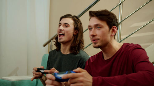 Homosexual couple playing video game at home