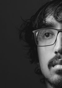 Close-up portrait of young man against black background