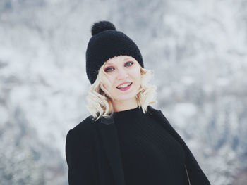 Portrait of mid adult woman standing on snow covered mountain