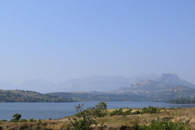 Scenic view of sea and mountains against clear sky