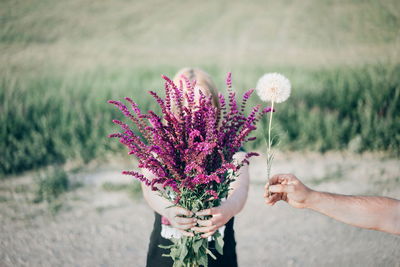 Close-up of woman holding flower against blurred background