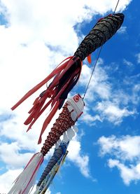 Low angle view of koinobori waving against sky