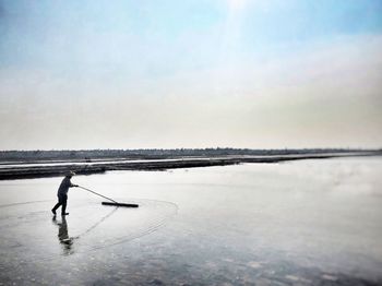 Man standing in sea against sky