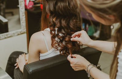 Portrait of a young girl doing her hair at the hairdresser.