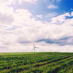 Scenic view of field against cloudy sky