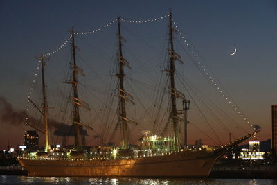 Sailboats in harbor against sky at night