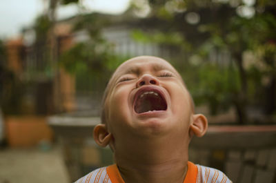 Close-up of cute boy crying outdoors